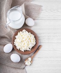 Milk and fresh eggs on a wooden board