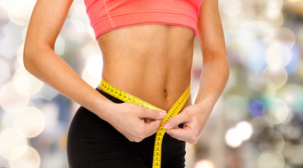 close up of female hands measuring waist