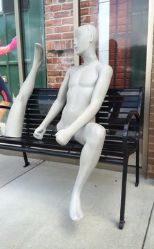 Undressed Mannequin Sitting On Bench