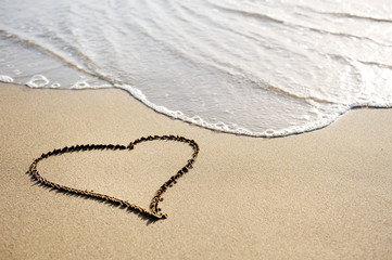 love concept - one heart drawn on the beach sand