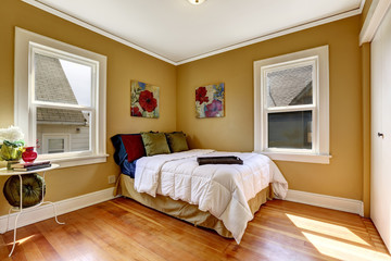 Simple bedroom with single bed in colorful bedding
