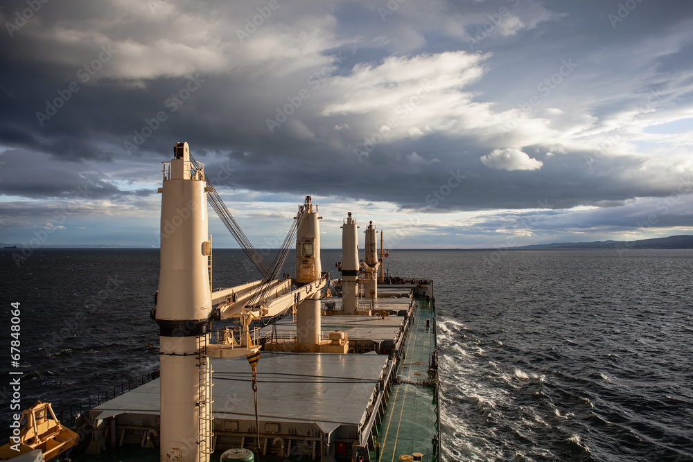 Wall mural cargo ship underway at cloudy day