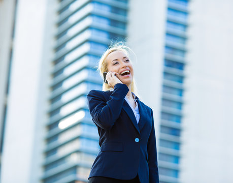 Happy businesswoman talking on a phone, corporate office