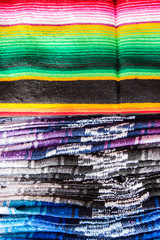 A stack of colorful woven blankets