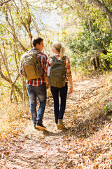 young couple walking in autumn forest