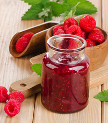 Glass jar of jam with fresh raspberries