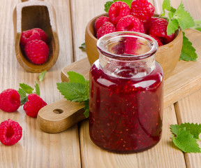 Glass jar of jam with fresh raspberries