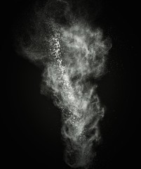 White powder exploding isolated on black