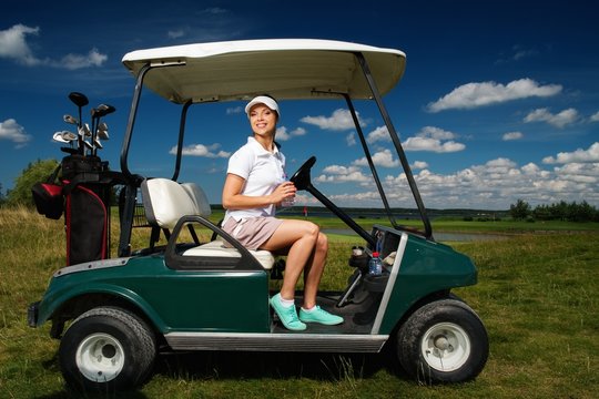 Young Cheerful Woman Driving Golf Cart