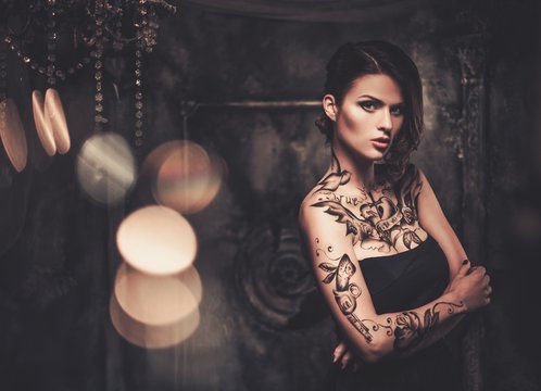 Tattooed beautiful woman in old spooky interior