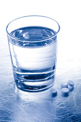 Glass of water and pills