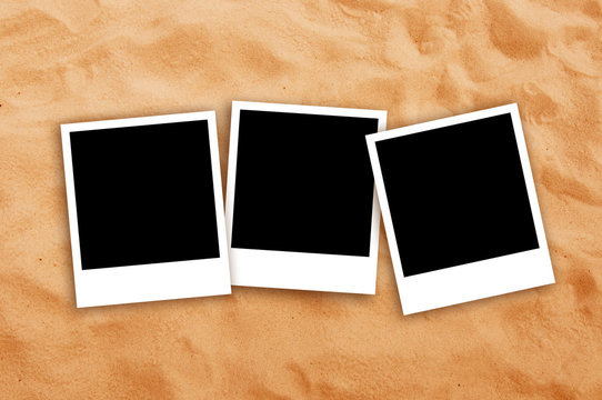 Three Blank photo frames on beach sand
