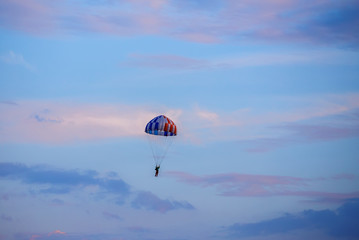 unidentified skydiver, parachutist on blue sky