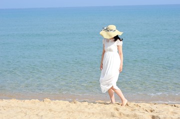 Fototapeta na wymiar 海と白いワンピースを着た女性