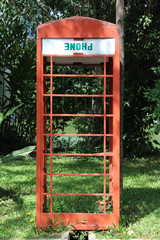 Fototapeta na wymiar Old red telephone box in the park.