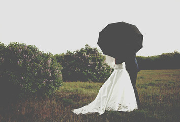 bride and groom under umbrella