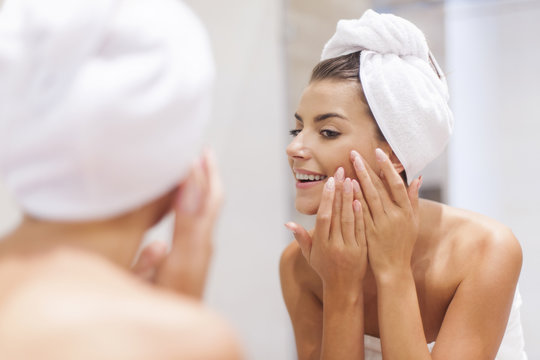 Woman removing pimple from her face