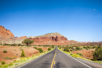 Fototapeta na wymiar Straight road through empty wilderness in Utah
