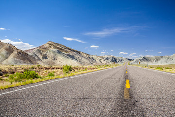 Asphalt road through grey mountains