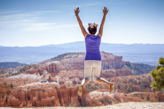 Young woman joyfully jumping in Bryce Canyon Park