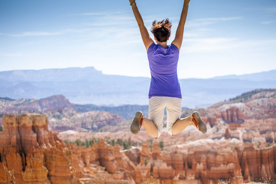 Young Woman Joyfully Jumping In Bryce Canyon Park