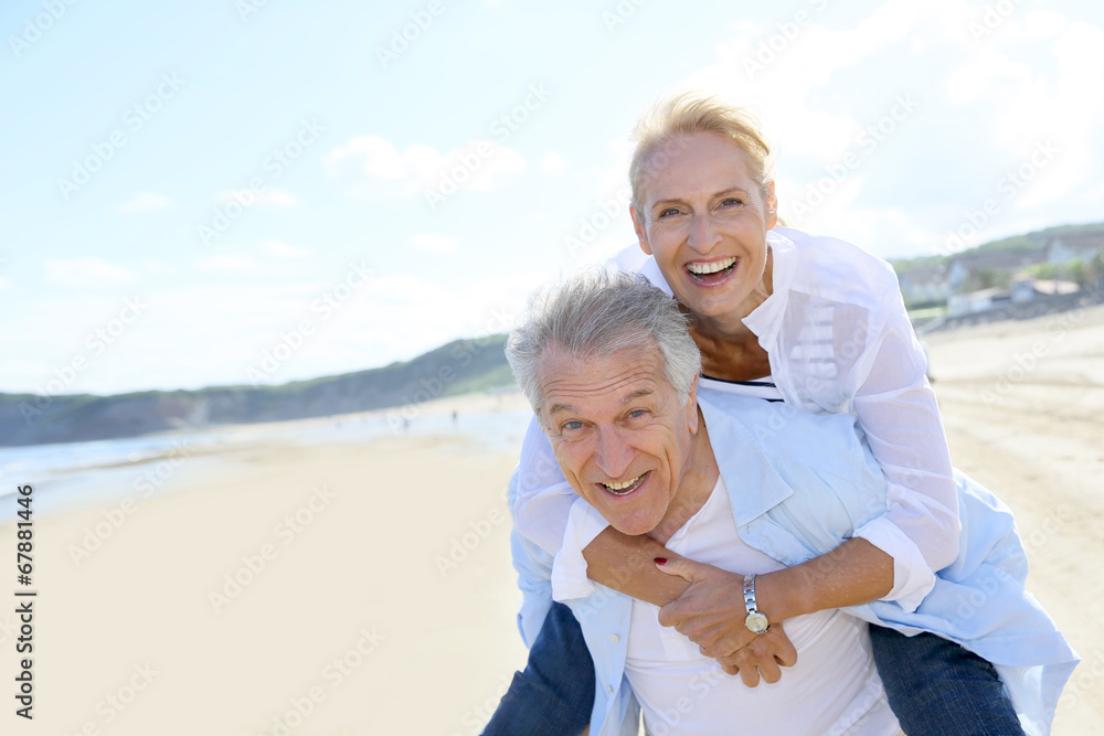 Wall mural senior man giving piggyback ride to wife