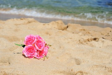 砂浜とピンクの花束
