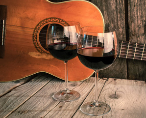 Fototapety  gitara i wino na drewnianym stole romantyczna kolacja w tle
