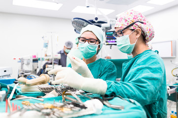 two scrub nurse preparing tools