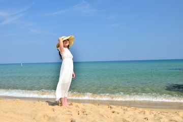 Fototapeta na wymiar 白いドレスを着た女性とビーチ