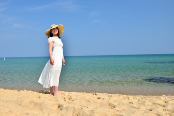 Fototapeta na wymiar 白いドレスを着た女性とビーチ