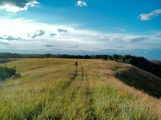 Man walking down country road in field,   Belgorod Oblast. Russi