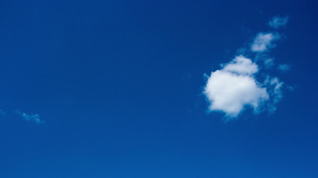 Small white cloud in the blue sky, timelapse