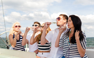 smiling friends with glasses of champagne on yacht