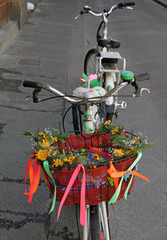 bike with  basket decorated with blooms parked on street