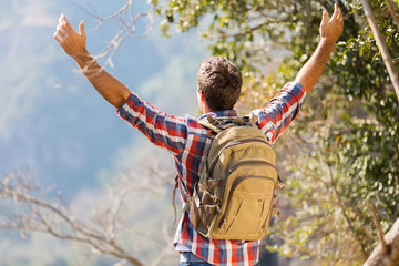 hiker with arms open on top of the mountain