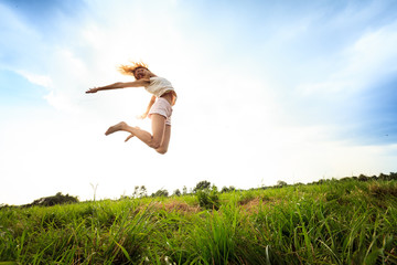 Jumping girl at field in summer