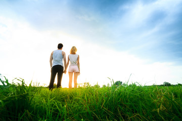 couple walking through the field and holding hands