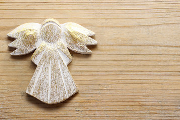 Golden angel on wooden background.