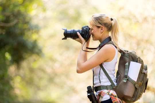 female photographer taking photos in mountain valley