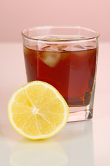 Fototapeta na wymiar Glass of whiskey with ice and lemon on red background