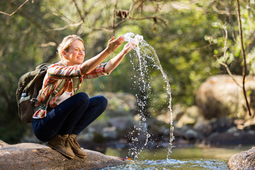 young hiker playing with stream water