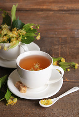 Tasty herbal tea with linden flowers on wooden table