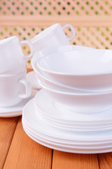 Set of white dishes on table on light background