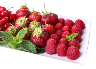 Forest berries on plate, isolated on white