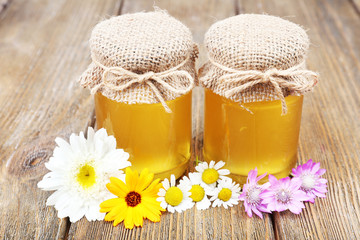 Obraz na płótnie Canvas Jar full of delicious fresh honey and wild flowers