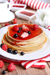 Sweet pancakes with berries on table close-up