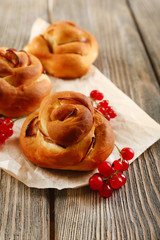 Tasty buns with berries on table close-up
