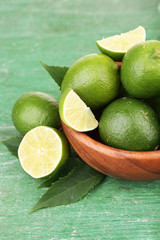 Fresh juicy limes in bowl  old wooden table