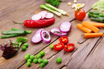 Different kind of raw vegetables on wooden table